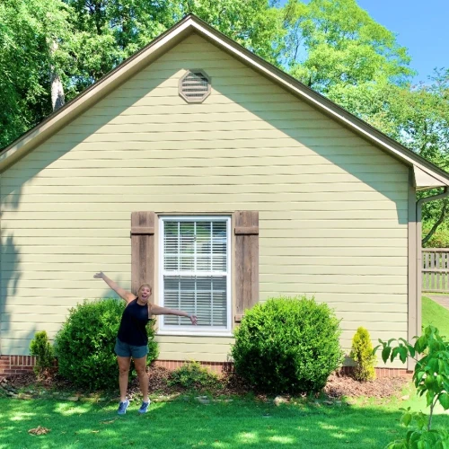 Excited female client standing outside home