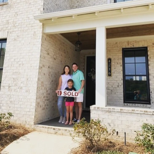Happy family holding sold sign